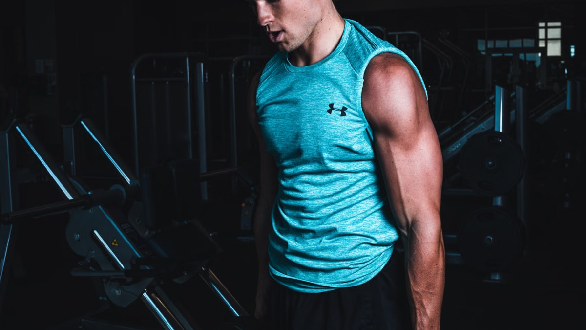Man exercising indoors, lifting dumbbells for strength training in a Towson gym.